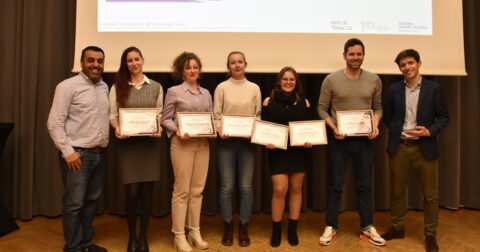 Groupe de lauréats souriants tenant des diplômes, célébrant l'esprit d'entreprendre lors d'une cérémonie de remise de prix.
