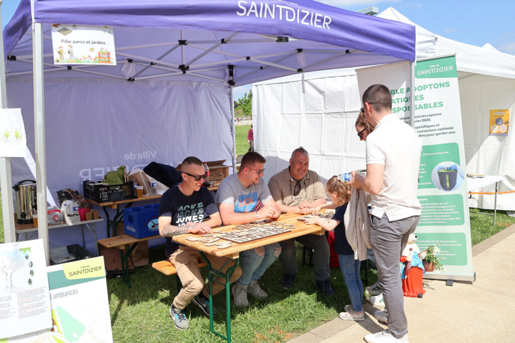 Stand de jeux en bois lors d'un événement à Saint-Dizier, avec enfants et adultes s'amusant sous une tente blanche.